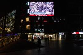 La gente mira una transmisión en una pantalla en un centro comercial sobre los ataques aéreos estadounidenses e israelíes en Irán y el contraataque de Irán, en Beijing, China.
