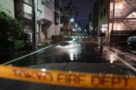 Rescatistas del Departamento de Bomberos de Tokio junto a un camino parcialmente inundado, la madrugada del domingo.
