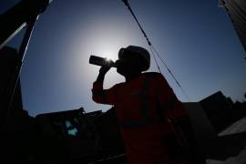 Una persona toma agua mientras trabaja en una construcción bajo un intenso calor, el 24 de junio de 2026, en Boulogne Billancourt, a las afueras de París.