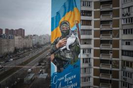 Un mural del soldado Oleksiy Movchan con un gato rescatado en sus brazos momentos antes de su muerte, en un edificio en Kiev, Ucrania, el 1 de febrero de 2024. El texto dice “Gloria a los héroes de Ucrania”.
