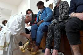 El papa Francisco (izquierda) lava los pies de un recluso dentro de la prisión de Civitavecchia, cerca de Roma.