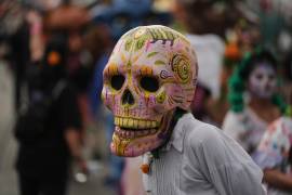 Una persona con una máscara de calavera desfila en la procesión anual del Día de Muertos en la Ciudad de México. La esperanza de vida en el País es de 75.5 años en promedio.