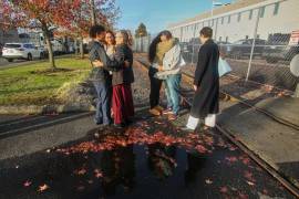 Inmigrantes de Portland, incluido Victor Cruz, en el centro a la derecha con la sudadera gris, abrazan a familiares tras ser liberados bajo fianza en Tacoma, Washington, el viernes 7 de noviembre de 2025.