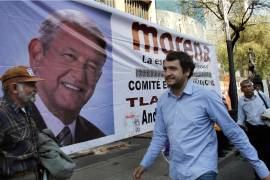Andrés López Beltrán, en el centro, pasa junto a una pancarta con la imagen de su padre, Andrés Manuel López Obrador, en la Ciudad de México, el 6 de diciembre de 2013.