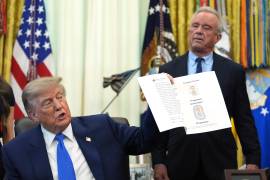 El presidente estadounidense Donald Trump, junto al secretario de Salud Robert F. Kennedy Jr.,sostiene una imagen tomada de su cuenta en Truth Social, durante la firma de una orden ejecutiva sobre vacunación.