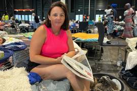 Morgane Bonichot, de 40 años, se toma un descanso de leer el periódico en un centro de evacuación en Burdeos, donde ella, su hija, su conejo y su perro se refugian de los incendios en el sur de Francia.