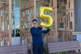 Joseph Parra Miguel, de 18 años e hijo de inmigrantes mexicanos, sosteniendo un globo en forma del número cinco en alusión a su logro de 5 millones de dólares en becas.