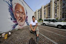 La artista italiana Trisha posa frente a su mural dedicado al encarcelado fundador de WikiLeaks, Julian Assange, para celebrar su ciudadanía honoraria, otorgada por la ciudad de Nápoles.