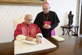El papa León XIV firma la exhortación apostólica con el título ‘Dilexi te’ en presencia de monseñor Edgar Peña Parra en la biblioteca privada del Palacio Apostólico en el Vaticano.