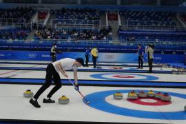 Bruce Mouat, de Gran Bretaña, barre durante la ronda de semifinales del partido de curling de dobles mixtos contra en los Juegos Olímpicos de Invierno de Beijing en Beijing. AP/Brynn Anderson