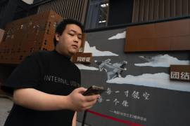 Un hombre pasa junto a un mural que pide la unidad civil militar en Beijing. Medios estatales chinos dicen que un aficionado a la historia militar encontró una colección de documentos confidenciales.