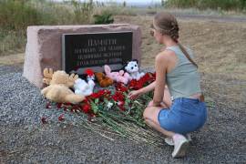 Una mujer deposita flores en el monumento a las víctimas en una ceremonia en el lugar del accidente del avión MH17, en el décimo aniversario, cerca del pueblo de Grabovo, a unos 100 kilómetros al este de Donetsk.