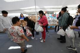 Personas recogen alimentos en una distribución temporal organizada por el Banco de Alimentos Comunitario del Condado de Alameda en Oakland, California.