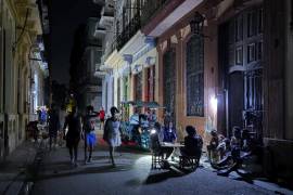 Personas alumbran con lámparas una calle durante un apagón en La Habana. Un promedio de dos o tres horas de electricidad tendrán los 9.4 millones de cubanos este jueves.