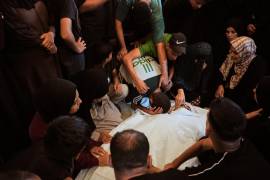 Palestinos lloran sobre el cuerpo de Izz al-Din Barhoum, de 22 años, un miliciano de la Yihad Islámica que murió por ataques israelíes, en su funeral en el Hospital Nasser de Jan Yunis, Franja de Gaza.
