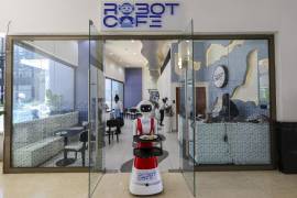 Un camarero robótico (c) entrega comida a un cliente en el Robot Café, el primer restaurante robótico en África Oriental y el segundo en el continente que emplea robots humanoides en Kileleshwa, Nairobi, Kenia.