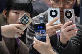 Varios visitantes observan el funcionamiento de la cámara ‘tracking’ para móviles de un teléfono Honor, durante la jornada inaugural de la vigésima edición del Mobile World Congress (MWC) en Barcelona.