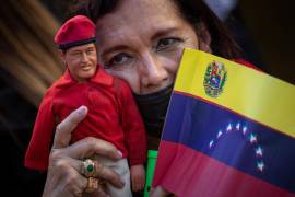 Una mujer carga un muñeco del expresidente fallecido Hugo Chávez durante una marcha adepta al gobierno de Nicolás Maduro en Caracas, Venezuela.