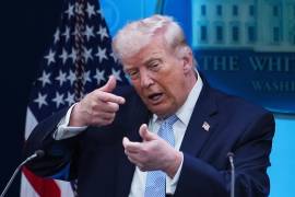 El presidente Donald Trump simula apuntar con un fusil de francotirador al hablar con periodistas en la sala de prensa James Brady de la Casa Blanca en Washington.