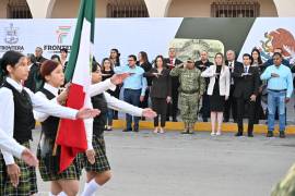 Niñas, niños y jóvenes participan en los honores a la bandera durante el evento cívico.