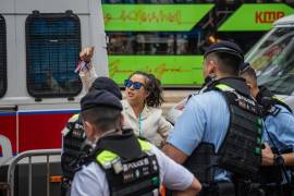 Una mujer es detenida y registrada por agentes de policía en Causeway Bay, cerca de Victoria Park en Hong Kong, China.