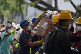 Los rescatistas distribuyen paquetes de alimentos a los equipos de rescate y voluntarios que buscan entre los escombros cuatro días después del terremoto.