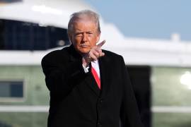 President Donald Trump points as he boards Air Force One for a trip to Detroit, Tuesday, Jan. 13, 2026, in Joint Base Andrews, Md. (AP Photo/Evan Vucci)