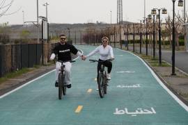 Una pareja pasea en bicicleta junto al lago artificial de los Mártires del Golfo Pérsico durante las festividades del Año Nuevo iraní en el oeste de Teherán, Irán.