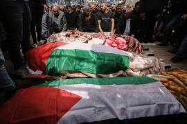 Palestinos oran en el funeral de tres mujeres palestinas que murieron en un ataque iraní en el poblado de Beit Awa, en Cisjordania, cerca de Hebrón, el jueves 19 de marzo de 2026. (AP Foto/Mahmoud Illean)