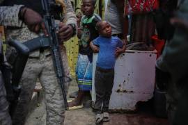 Niños al lado de policías, durante la visita de la delegada del Programa Mundial de Alimentos, la princesa Sarah Zeid de Jordania, en un refugio para familias desplazadas en Puerto Príncipe, informó AP.