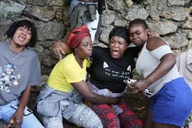 Varias mujeres se lamentan en el lugar donde sus familiares fueron asesinados durante un ataque de pandillas en el barrio de Kenscoff, el lunes 24 de agosto de 2026, en Puerto Príncipe, Haití. (AP Foto/Odelyn Joseph)