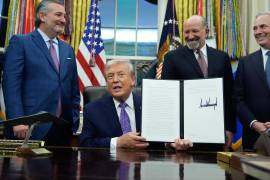 Flanqueado por el senador republicano de Texas, Ted Cruz, izquierda, el secretario de Comercio Howard Lutnick, segundo a la derecha, y el zar de la IA y las criptomonedas de la Casa Blanca, David Sacks, el presidente Donald Trump muestra su iniciativa firmada sobre IA en el Despacho Oval de la Casa Blanca, el 11 de diciembre de 2025, en Washington.