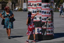 Una niña señala carteles con los rostros de desaparecidos en Guadalajara, Jalisco.