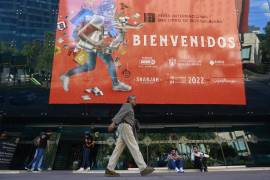 Un hombre camina frente a un anuncio de la edición 36 de la Feria Internacional del Libro de Guadalajara.