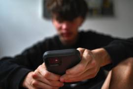 Un adolescente utiliza su celular para ver redes sociales, en Sydney, Australia. Australia prohíbe el acceso a redes sociales a los menores de 16 años.