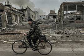 Un hombre circula en bicicleta frente a la oficina de correos destruida por un ataque aéreo ruso en Kurájove, en la región ucraniana de Donetsk, el 7 de noviembre de 2024. FOTO: AP.