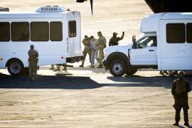 Agentes de seguridad custodian el traslado de un ciudadano cubano en la pista de aterrizaje de la base, muchos de estos hombres fueron llevados a Guantánamo bajo la promesa de una deportación directa que terminó en semanas de aislamiento.