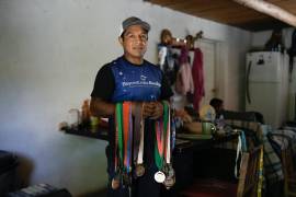 El ultramaratonista Miguel Lara posa para una fotografía con algunas de sus medallas en su casa en Porochi, una comunidad indígena en las remotas montañas Tarahumara del norte de México.