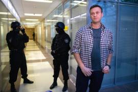 El líder opositor ruso Alexei Navalny habla con los medios frente a agentes de seguridad que custodian la oficina de la Fundación para la Lucha contra la Corrupción en Moscú, Rusia, el 26 de diciembre de 2019.