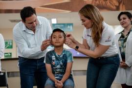 El alcalde Javier Díaz y su esposa Luly López colocan de forma simbólica un aparato auditivo a una beneficiaria del programa del DIF Saltillo.