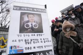 La gente pasa junto a una pancarta que exige el arresto del presidente surcoreano destituido, Yoon Suk Yeol, cerca de la residencia presidencial en Seúl, Corea del Sur.