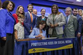 La gobernadora de Nueva York, Kathy Hochul (centro), firma el proyecto de ley “Ley de seguridad para los niños” en la oficina municipal de Manhattan de la Federación Unida de Maestros, en Nueva York.