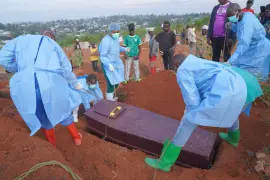 Varias personas con equipos de protección colocan un ataúd con los restos de Baudjo Baraka Jules, de 6 años y que murió de ébola, en una tumba, en Bunia, en la provincia de Ituri, República Democrática del Congo, el 18 de agosto de 2026.
