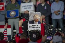 Un partidario del candidato republicano a la presidencia, el expresidente estadounidense Donald Trump, sostiene un cartel durante un mitin en la Universidad de New Hampshire en Durham.