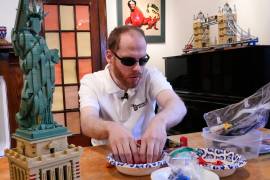 Matthew Shifrin, fundador de Bricks for the Blind, palpa piezas específicas mientras construye una máquina expendedora de chicles a base de piezas de Lego en la casa de su familia en Newton, Massachusetts.