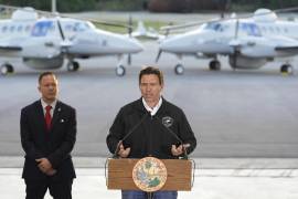 El gobernador de Florida Ron DeSantis habla en compañía de Keith Pearson, un asesor senior del Departamento de Seguridad Nacional, en conferencia de prensa en el hangar de la Oficina de Aduanas y Protección Fronteriza de Estados Unidos en la Base de la Fuerza Aérea en Homestead, Florida. FOTO: