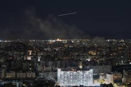 Un avión de Middle East Airlines vuela mientras se eleva humo tras los ataques aéreos israelíes en Dahiyeh, un suburbio al sur de Beirut, Líbano.