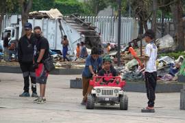 Niños migrantes juegan mientras un grupo de personas desmantelan el campamento que fue su hogar en el Parque Guadalupe Victoria en Ciudad de México.