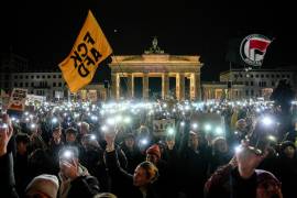 Una multitud sostiene sus teléfonos con la lámpara encendida mientras protestan contra el partido político de extrema derecha, Alternativa para Alemania o AfD por sus siglas en alemán, frente a la Puerta de Brandeburgo, en Berlín. FOTO: