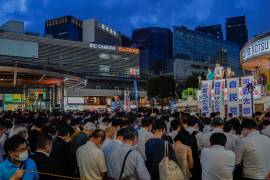 Los votantes hacen una pausa por un momento de silencio para conmemorar al ex primer ministro japonés Shinzo Abe antes del inicio de una campaña electoral callejera de la Cámara Alta en Tokio, Japón.